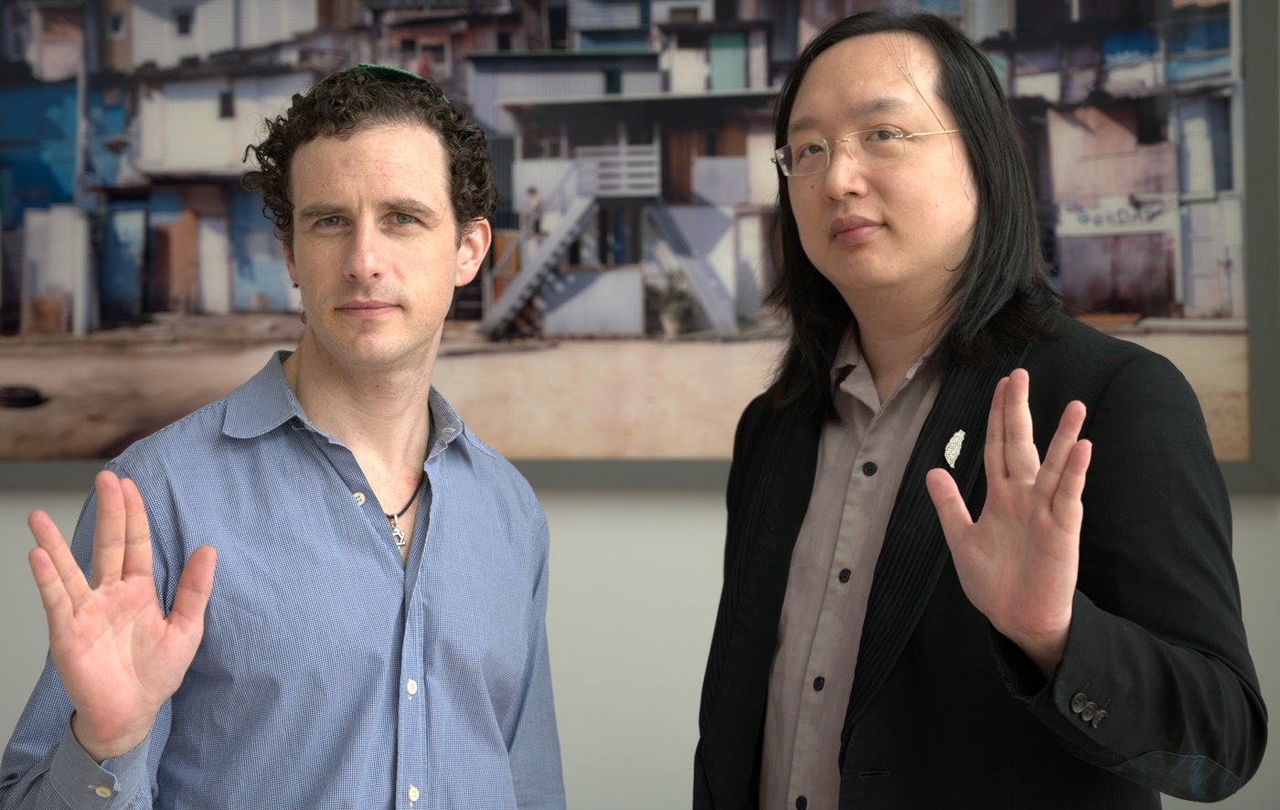 Official Plurality author-page photograph of Glen Weyl and Audrey Tang standing side by side with raised hands.